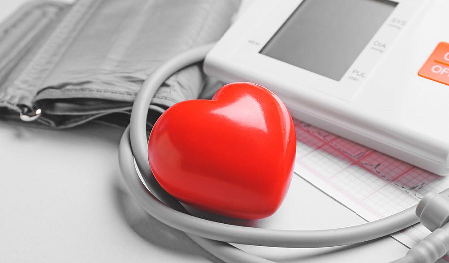 Foto de monitor de presión arterial y corazón rojo.